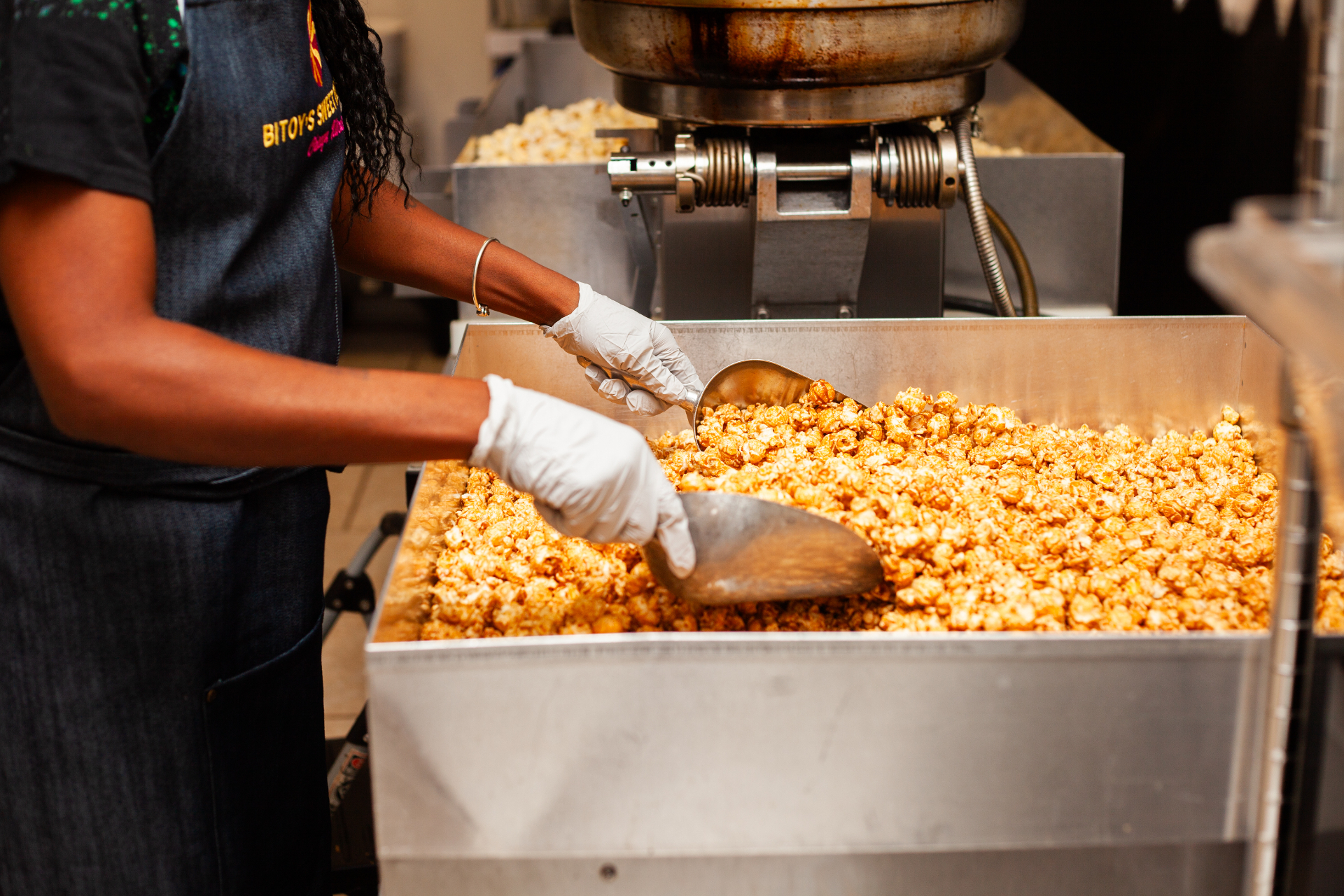 Hands tossing fresh caramel popcorn in the Bitoy's kitchen